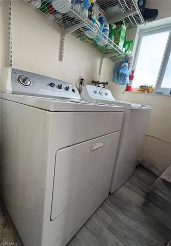 Laundry room with independent washer and dryer and wood finished floors