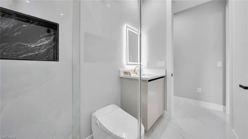 Bathroom featuring vanity and light marble finish flooring