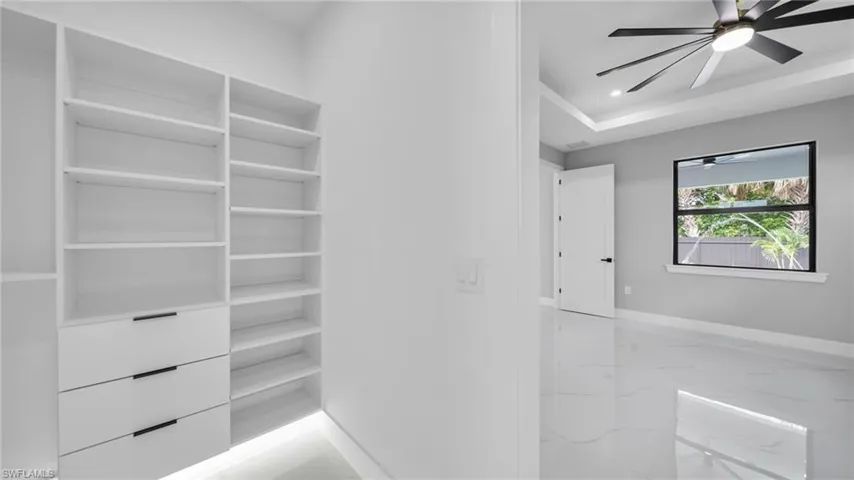 Bathroom featuring light marble finish floors, a ceiling fan, and recessed lighting