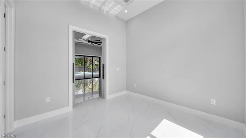 Spare room featuring light marble finish floors and ceiling fan