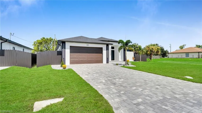 View of front of home with an attached garage, stucco siding, decorative driveway, and a shingled roof