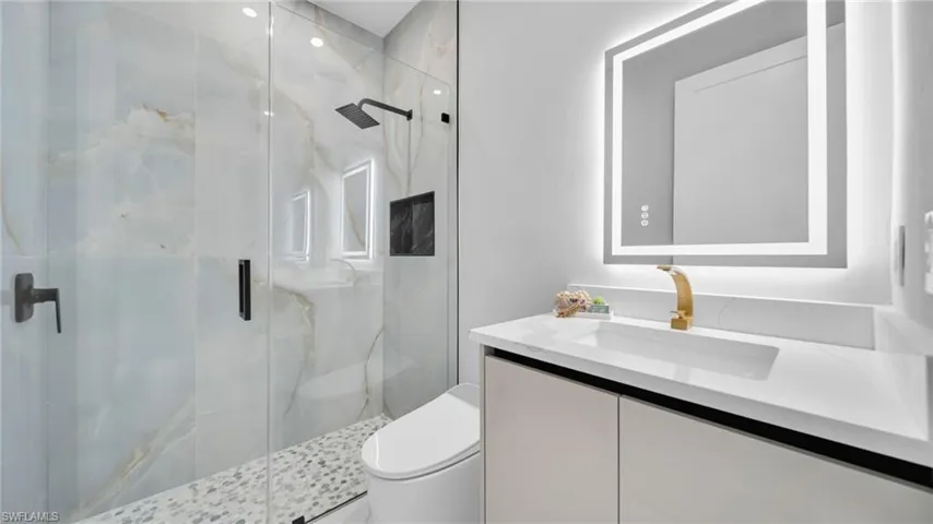 Full bath with vanity and a marble finish shower