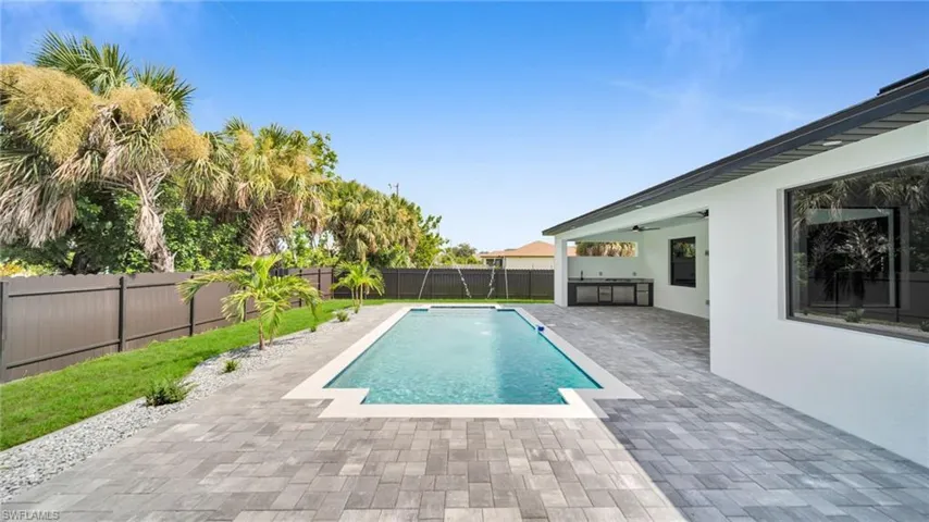 View of pool with a fenced backyard, a patio, and ceiling fan