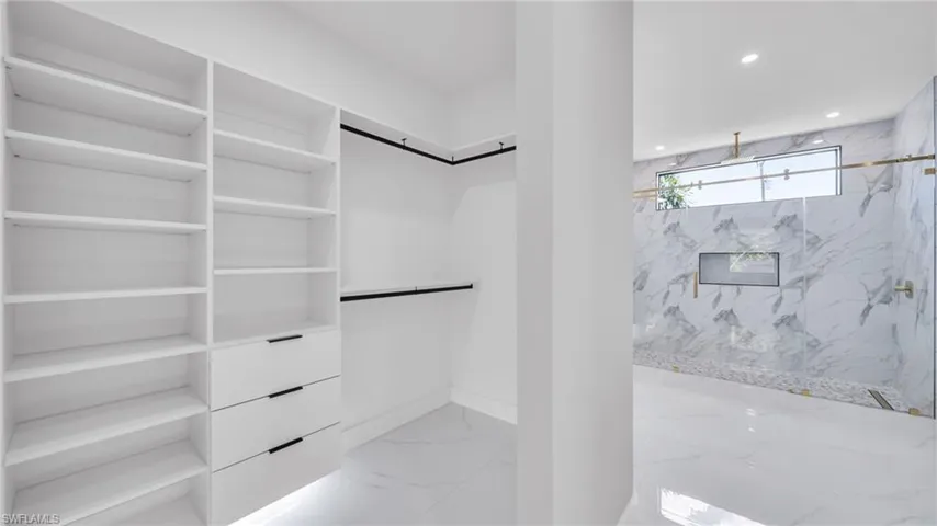 Walk in closet with light marble finish floors