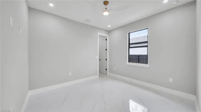 Spare room featuring marble finish floors, recessed lighting, and a ceiling fan