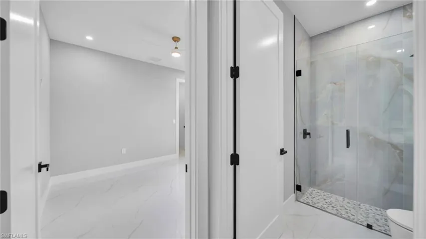 Bathroom with a marble finish shower, recessed lighting, marble finish floors, and ceiling fan