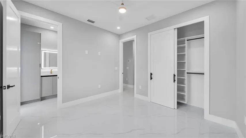 Unfurnished bedroom with light marble finish floors, a closet, recessed lighting, and a ceiling fan