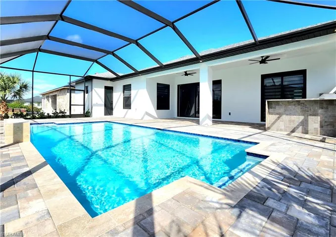 Outdoor pool featuring a lanai, a patio area, ceiling fan, and outdoor dry bar