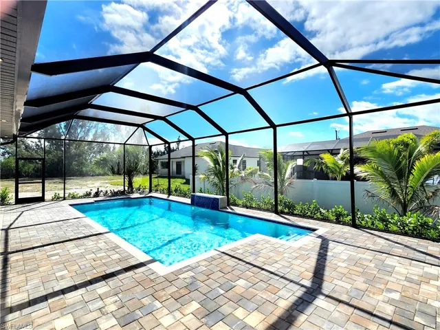 Pool with glass enclosure and a patio area