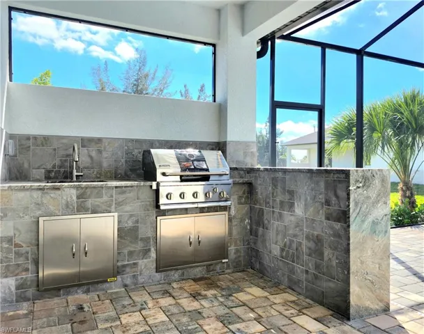 View of patio / terrace featuring area for grilling, grilling area, a sink, and a lanai