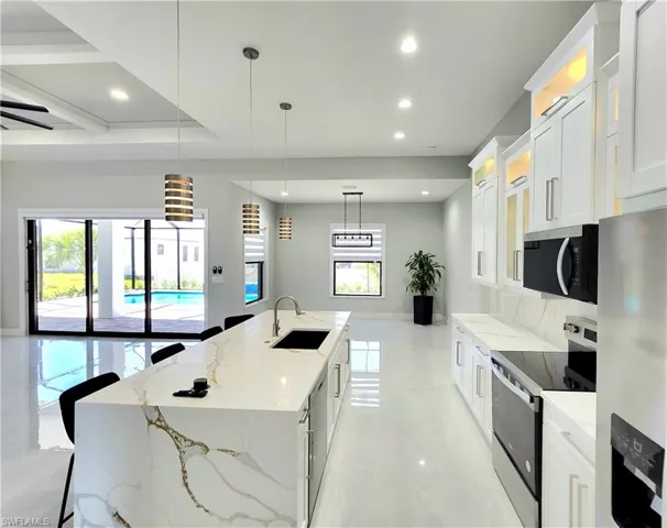 Kitchen with stainless steel appliances, white cabinets, and a sink