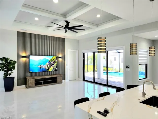 Living room with coffered ceiling, a towering ceiling, ceiling fan, beamed ceiling, and recessed lighting