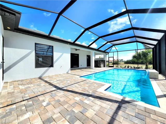 Outdoor pool featuring a lanai, a patio area, and a ceiling fan