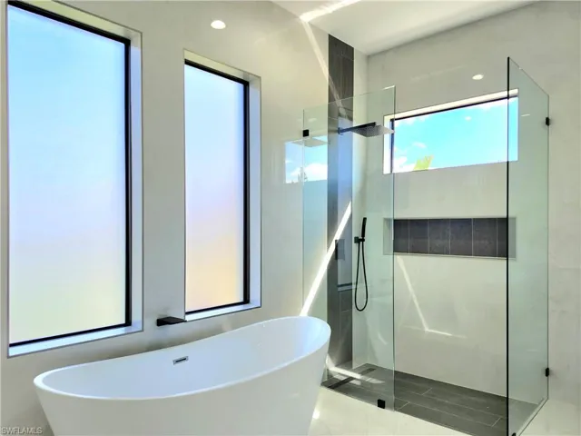 Full bath featuring a walk in shower and a freestanding tub