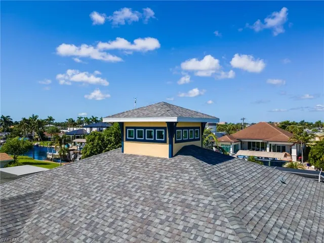 Asphalt shingle roof with a prominent cupola featuring multiple windows and a hip roof