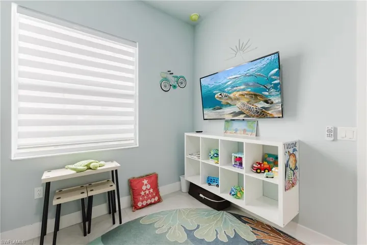 Light blue painted wall with a wall-mounted television and built-in white shelving unit