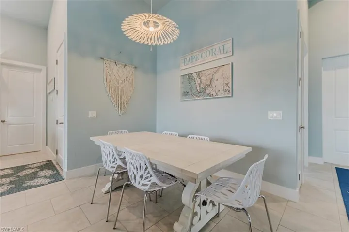 Dining area featuring light blue walls, a light-toned dining table, and tile flooring