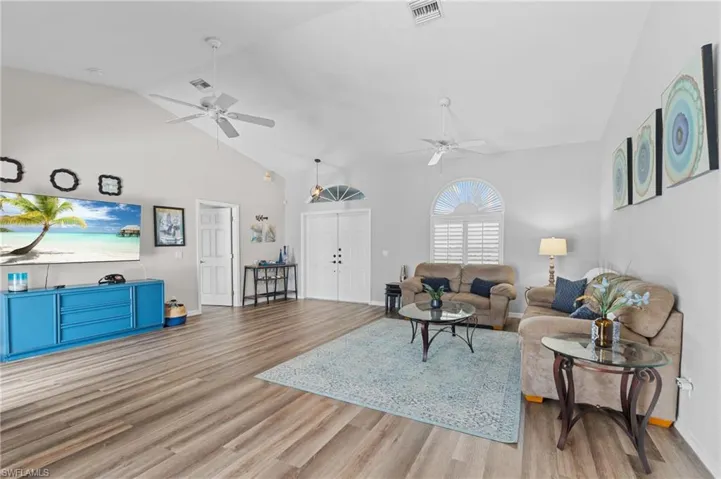 Living area with wood finished floors, ceiling fan, and visible vents