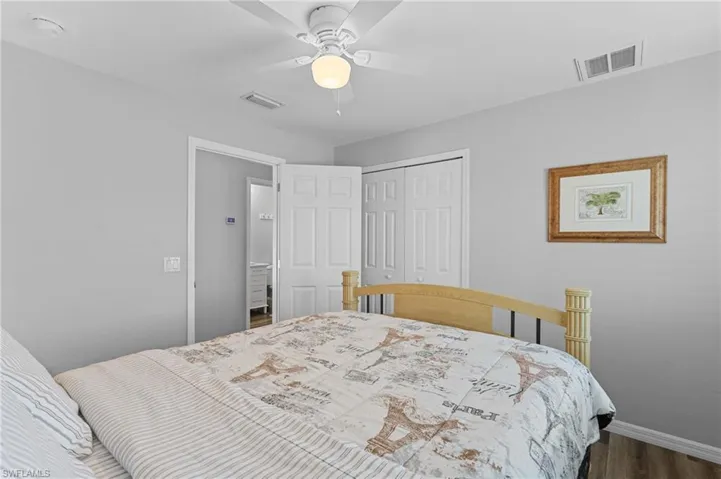 Bedroom featuring a closet, a ceiling fan, baseboards, visible vents, and dark wood-style flooring
