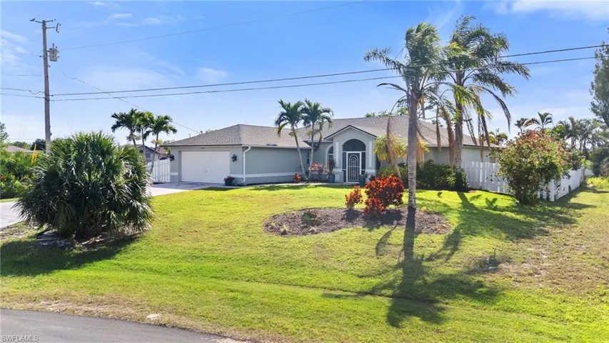 Single story home featuring a garage, fence, a front lawn, and concrete driveway