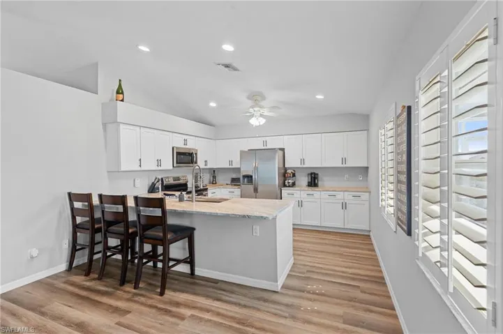 Kitchen with white cabinetry, a sink, visible vents, a peninsula, and appliances with stainless steel finishes