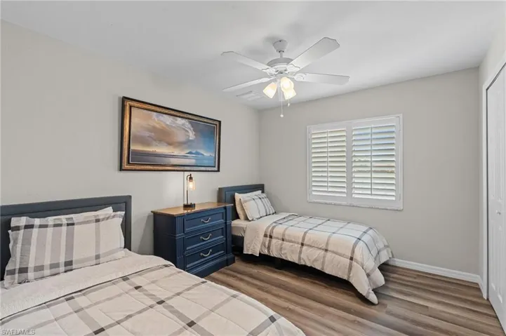 Bedroom featuring baseboards, a closet, ceiling fan, and dark wood-style flooring