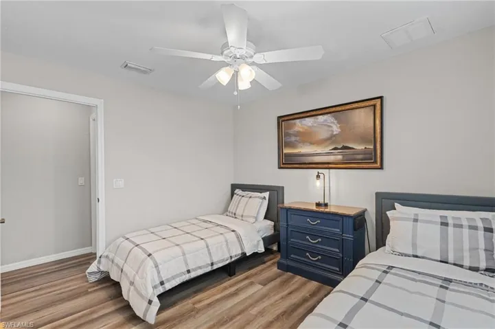 Bedroom with visible vents, baseboards, ceiling fan, and wood finished floors