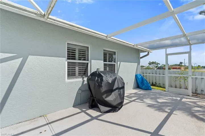 View of patio featuring a lanai, fence, and a grill
