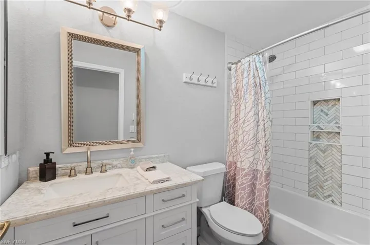 Bathroom featuring shower / tub combo, toilet, and vanity