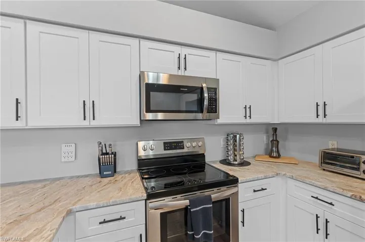 Kitchen featuring white cabinetry, stainless steel appliances, and a toaster