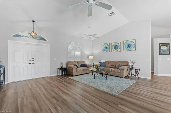 Living area with visible vents, a ceiling fan, and wood finished floors