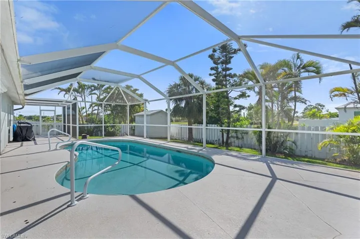 View of pool featuring a patio, a fenced in pool, a fenced backyard, an outdoor structure, and a shed