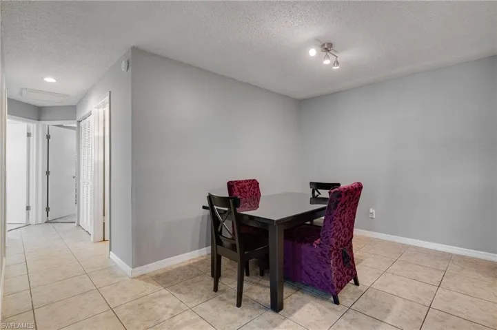 Dining space featuring light tile patterned floors and a textured ceiling