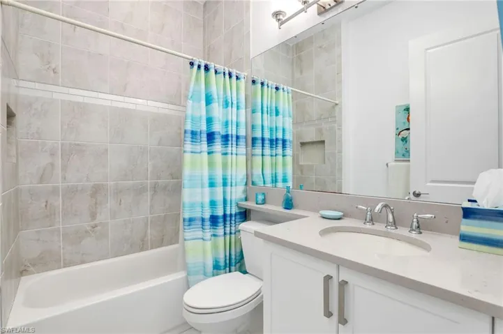 Full bathroom featuring shower / tub combo, vanity, and toilet