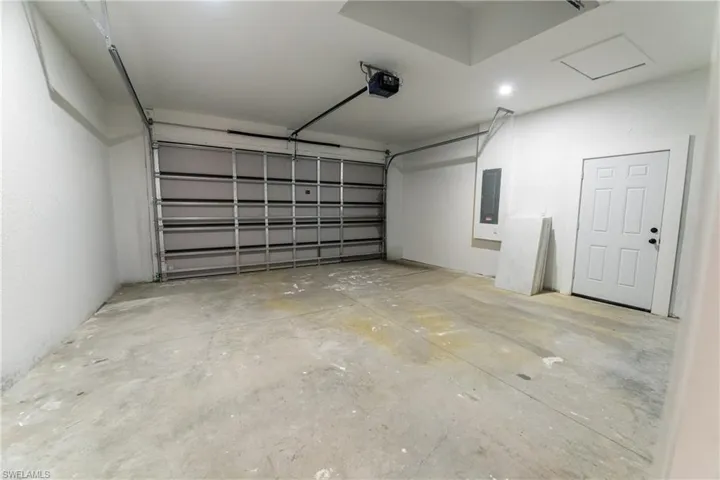 Garage featuring a garage door opener and electric panel