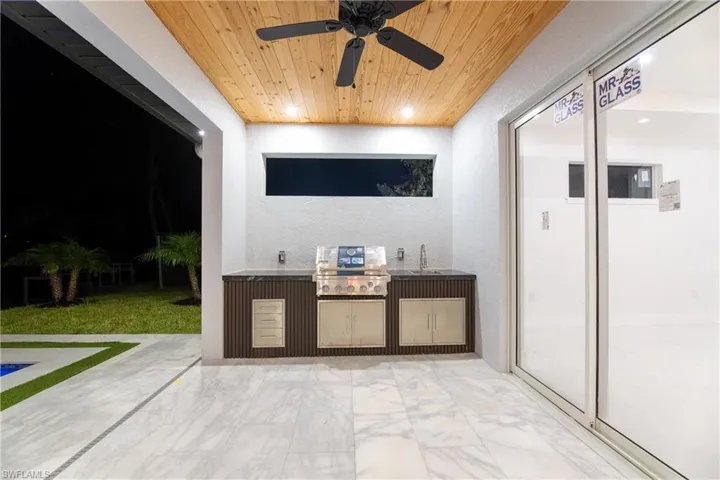 View of patio / terrace featuring area for grilling, sink, and ceiling fan