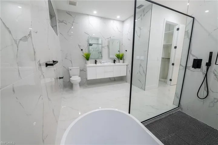 Bathroom featuring vanity, a bath, and toilet