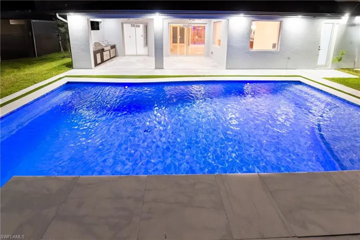 View of swimming pool with area for grilling and a patio area