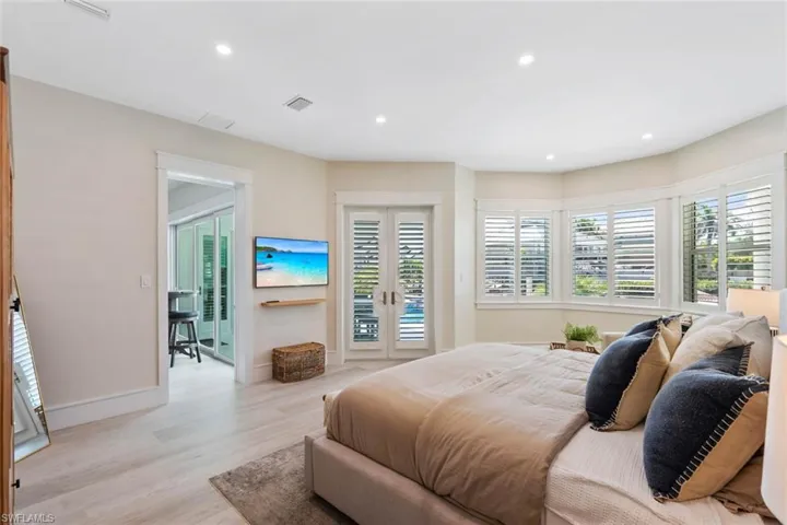 Bedroom with recessed lighting, wood finished floors, access to outside, and french doors
