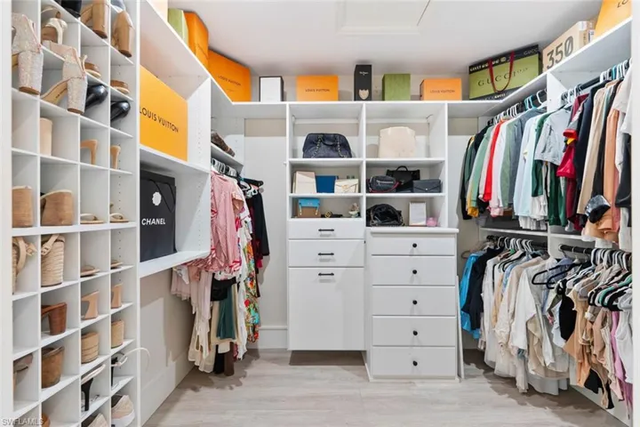 Walk in closet with light wood-style flooring