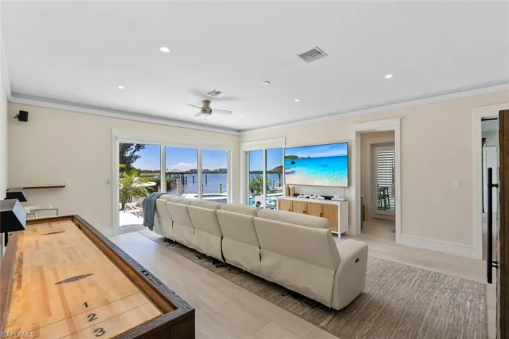 Living area featuring wood finished floors, recessed lighting, crown molding, and a ceiling fan
