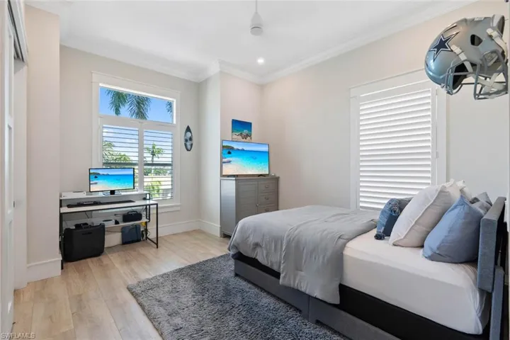 Bedroom with light wood-style flooring and ornamental molding