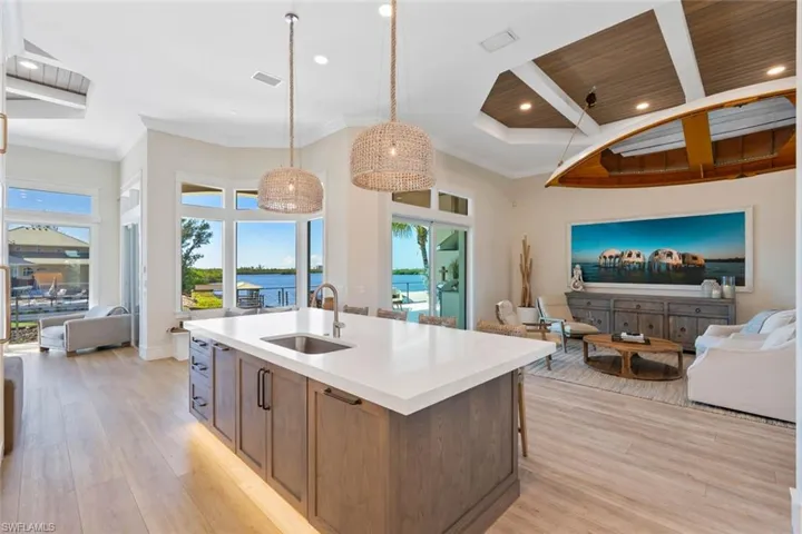 Kitchen featuring open floor plan, recessed lighting, light wood-style flooring, light stone counters, and hanging light fixtures