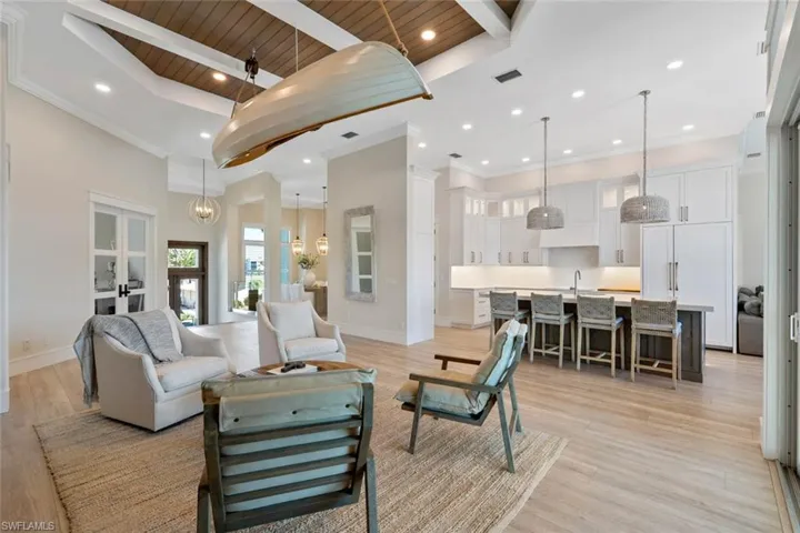 Living area featuring recessed lighting, light wood-type flooring, a towering ceiling, french doors, and a wooden ceiling with exposed beams