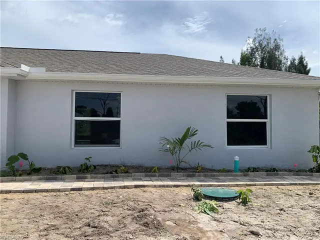 View of property exterior featuring a shingled roof and stucco siding