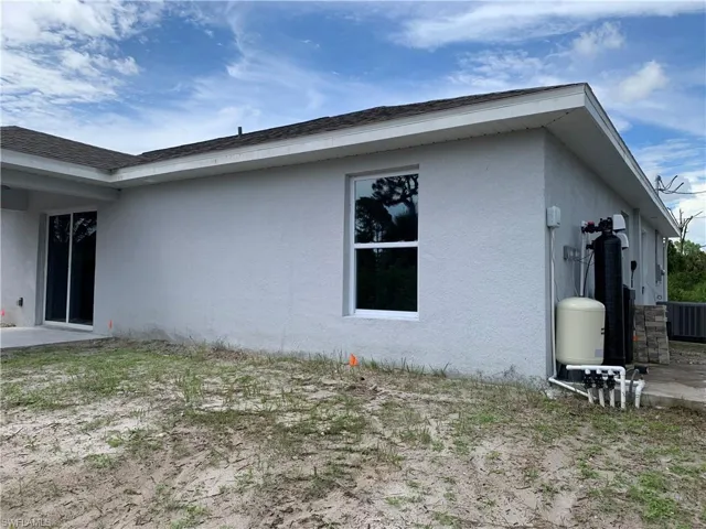 View of side of property featuring a patio area and stucco siding