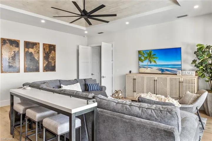 Living area with light wood-type flooring, recessed lighting, and a ceiling fan