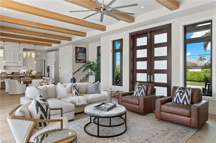 Living area featuring light wood finished floors, beamed ceiling, french doors, recessed lighting, and a ceiling fan