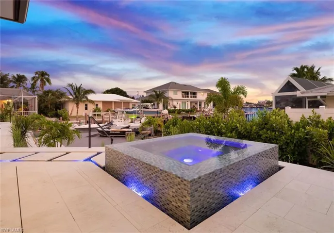 View of pool featuring a patio, an outdoor hot tub, and a water view