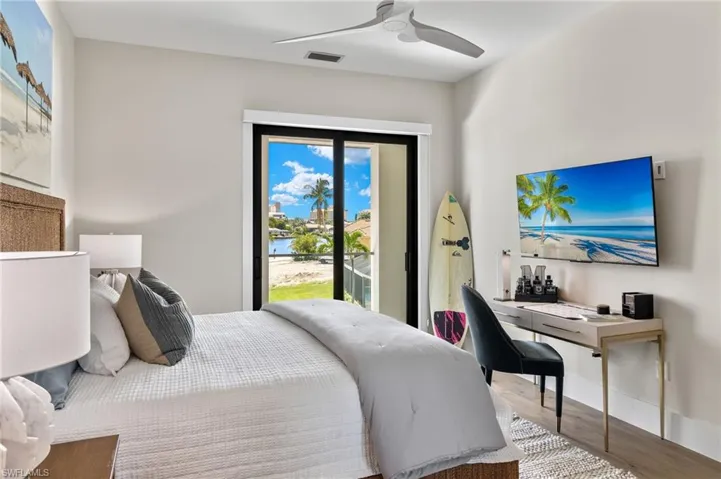 Bedroom featuring access to outside, a ceiling fan, wood finished floors, and a desk